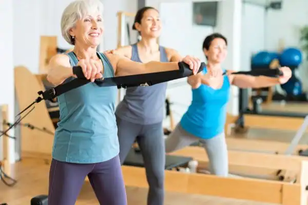 Toning Arms After 60: Empowering Womens Fitness Through Effective Weight Training 2 older woman doing weight training Lutterworth and resistance in the gym to tone upper arms