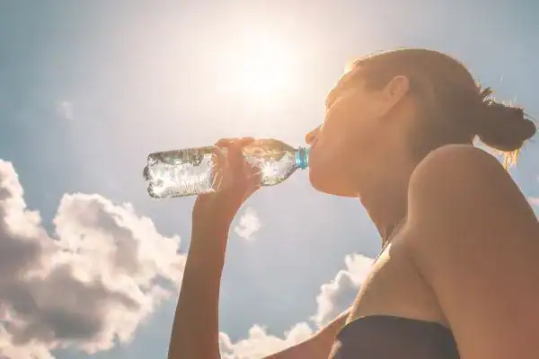 Hydration: The Secret Ingredient for a Toned Stomach and Enhanced Fitness 3 Image of woman drinking water to hydrate Lutterworth after run.